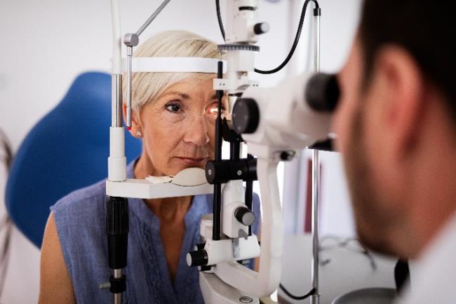 אישה מבוגרת עוברת בדיקה אצל רופא עיניים לאבחון של קטרקט